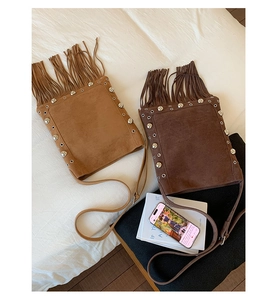 Detail of suede fringe shoulder bags with silver studs in light brown and dark coffee