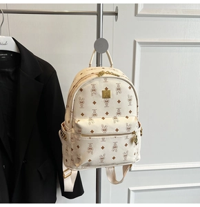 Close-up of white mini backpack featuring brown cartoon rabbit prints and gold rivets