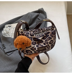 Detail of leopard print crossbody bag with cute teddy bear charm and adjustable strap