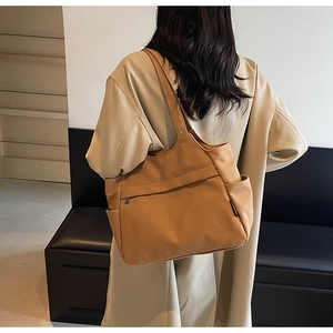 Dettaglio di una borsa tote in tela capiente con tessuto resistente e tasca laterale