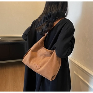 Vista dettagliata della borsa tote in pelle scamosciata marrone con patch logo in pelle