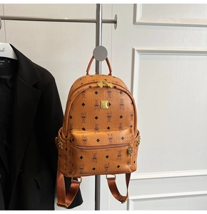 Close-up of brown backpack with bunny patterns and golden rivets on side pocket