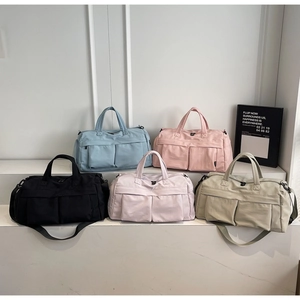 Multi-color nylon travel bags with dual handles and detachable straps shown on steps