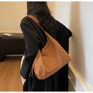 Borsa tote marrone opaca indossata dalla modella con blazer nero per il lavoro