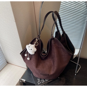 Close-up of deep brown suede tote bag featuring a cute white cloud plush charm detail