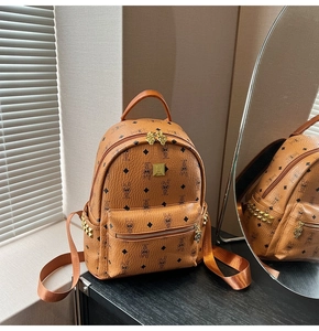 Detailed view of brown PU leather backpack with monogram pattern and gold metal rivets