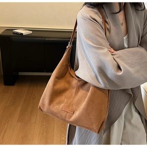 Dettaglio della borsa tote in pelle scamosciata marrone con grande capacità e texture in pelle