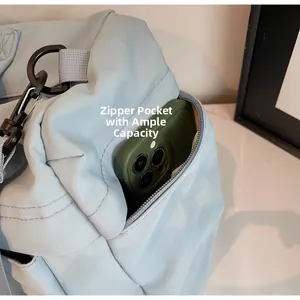 Detail view of the side zipper pocket on a light blue travel bag with a smartphone inside