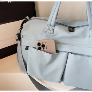 Detail view of water-resistant nylon travel bag with front pocket and durable metal zippers