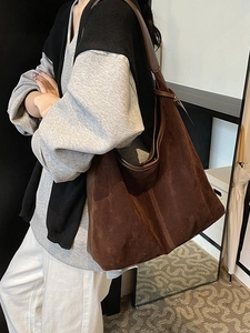 Grand sac hobo en cuir mat marron foncé porté par un mannequin pour le quotidien