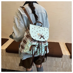 Detail of checkered backpack with star pattern and brown bow knot on the mint green flap
