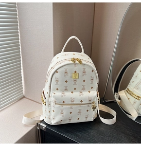 Close-up of leather backpack with rabbit print, golden rivets and metal logo plate