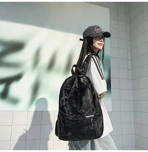 Outdoor street style view of a black camo backpack with durable texture and spacious pockets