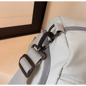 Close-up of durable black rotating swivel hook and grey nylon strap on travel bag