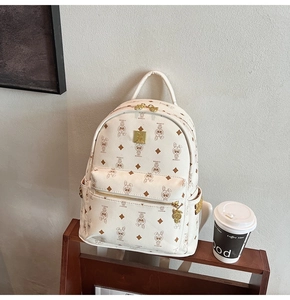 Detail of beige backpack with monogram print, rabbit pattern and golden metal plate