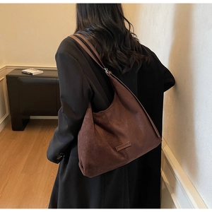 Dettaglio della borsa tote in pelle scamosciata marrone scuro con toppa in pelle