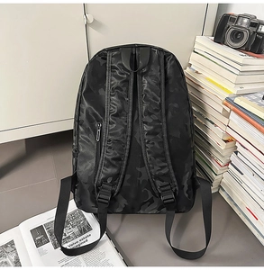 Detailed back view of black camo nylon backpack with adjustable straps and side zipper