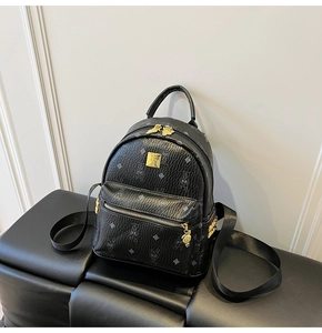 Detail of black leather backpack with monogram rabbit print and gold metal plate