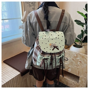 Detailed view of checkered backpack with mint green star pockets and bow decoration