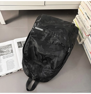 Detail of water-resistant black camo backpack with metal zipper and front pocket storage
