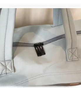 Detail of smooth black metal double zippers on light blue camo travel bag fabric