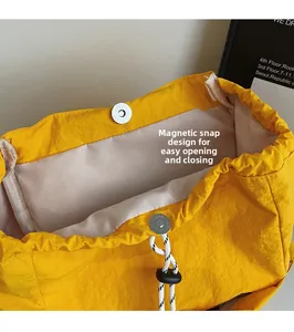 Primer plano de la mochila de nailon amarillo con hebilla magnética y cordón blanco y negro