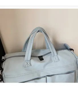 Detail of light blue travel bag featuring comfortable handles and sturdy metal zippers