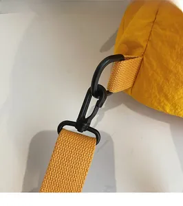 Detalle de gancho negro y correa tejida amarilla en una mochila de viaje moderna