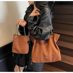 Ensemble sac cabas et sac seau en daim marron avec chaîne dorée sur un escalier en bois