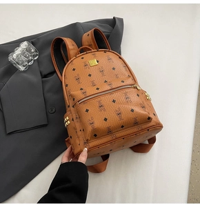 Close-up of caramel brown leather backpack with cartoon rabbit print and gold rivet side pocket