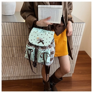 Detail of plaid backpack with mint green star pattern and brown ribbon bow