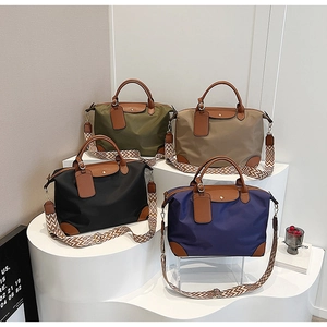 Detail of multi-color nylon tote bags with leather handles and patterned straps