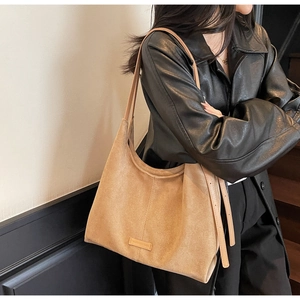 Dettaglio della trama in pelle scamosciata kaki e dei cinturini in pelle della borsa hobo