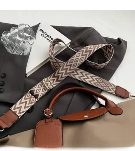 Detail of adjustable patterned fabric strap with leather trim and metal hook on tote bag