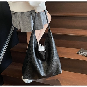 Detailed view of large black tote bag with unique crinkled faux leather texture and straps