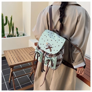 Detail of plaid mint green backpack with star print flap and cute ribbon bow accents