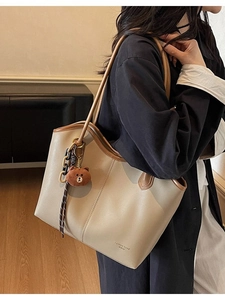 Chic beige large capacity tote bag with brown straps and plush bear charm on a model