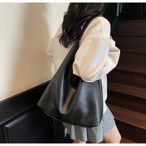 Close-up of black litchi pattern leather on large shoulder hobo bag shown on model