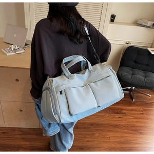 Lifestyle shot of a light blue large capacity travel bag with multiple storage pockets