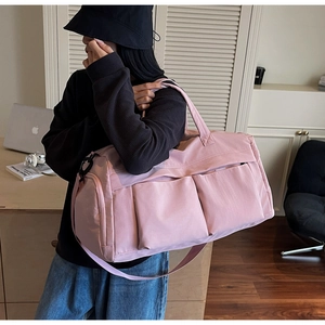 Detail of pink travel bag with multiple pockets and durable adjustable shoulder strap