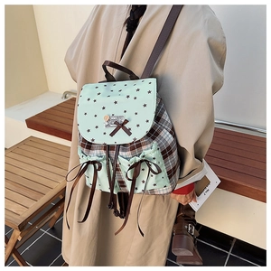 Detail of plaid backpack with mint green star pattern and brown ribbon bow decoration