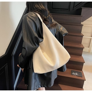 Detail of soft cream white pebbled leather texture on a large minimalist hobo tote bag
