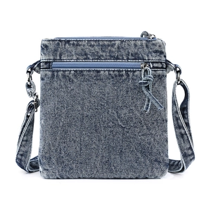 Detailed close-up of retro washed denim crossbody bag featuring layered zipper pockets