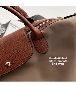 Macro detail of fine stitching and gold zipper on khaki nylon tote bag with leather trim