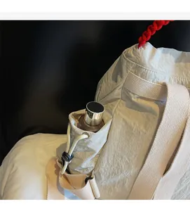 Dettaglio della tasca laterale con coulisse dello zaino beige con borraccia