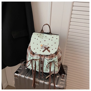 Close-up of retro plaid backpack with bow detail and star print on green front pockets
