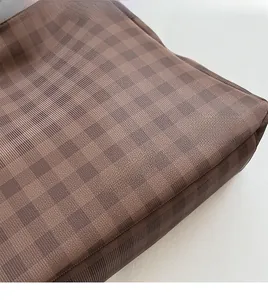 Dettaglio della trama a scacchi marrone con logo dorato Fashion & Bags stampato