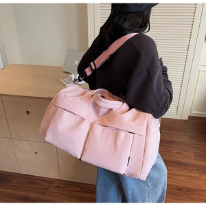 Detailed view of pink travel bag with adjustable strap in a modern home setting