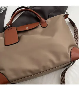 Detail of khaki nylon tote with leather handles and geometric patterned shoulder strap