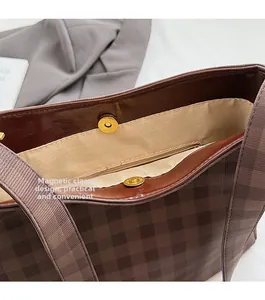 Dettaglio della borsa tote a quadri marrone con fibbia magnetica e tasca interna con cerniera